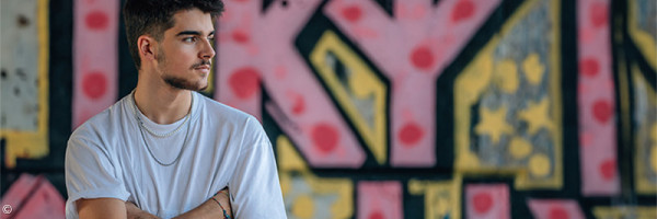 Foto: männlicher Teenager vor einer Wand mit Graffiti