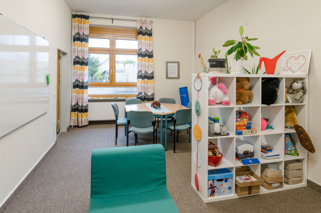 Foto: JaS Redwitz Grundschule: JaS-Raum mit Tisch und Regalen mit Spielen.