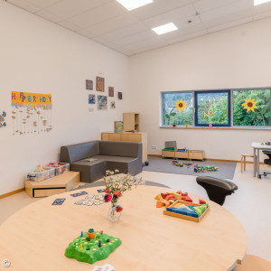 Foto: Mitwitz: Gruppenraum mit Tisch, Brettspielen und einem Sofa